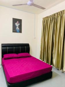 Schlafzimmer mit einem Bett mit rosa Bettwäsche und einem Fenster in der Unterkunft Abbie's Homestay Butterworth Penang in Butterworth