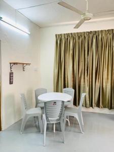 einen Tisch und Stühle in einem Zimmer mit Deckenventilator in der Unterkunft Abbie's Homestay Butterworth Penang in Butterworth