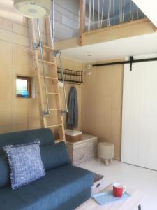 Una sala de estar con un sofá azul y una escalera. en Tiny Home cabin Eilidh, en Cowes
