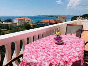 een tafel met een roze tafelkleed op een balkon bij Grgo Apartments in Drage