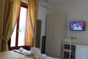 um quarto com uma cama, uma televisão e uma janela em Hotel Al Bosco em Ischia