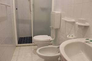 łazienka z toaletą, umywalką i prysznicem w obiekcie Hotel Al Bosco w mieście Ischia