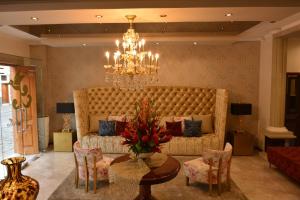 a living room with a large couch and a chandelier at Alejandrina Hotel in Cuenca