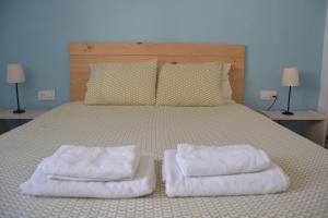 a bedroom with a bed with two towels on it at Casa "La Breña". Surf,sol y relax. in Los Caños de Meca