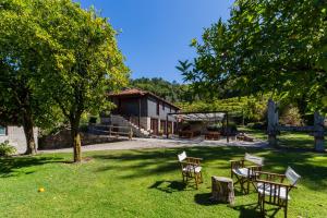 Quinta da Pousadela - Agroturismo في أمارانتي: مجموعة من الكراسي والطاولات في الفناء