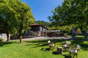 um grupo de cadeiras e mesas num quintal em Quinta da Pousadela - Agroturismo em Amarante