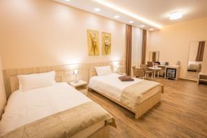 una camera da letto con due letti e un soggiorno di Hotel Mar Garni a Belgrado Altre 37 foto