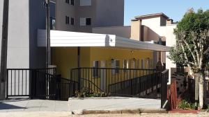 馬塞利諾拉莫斯的住宿－Casa Amarela，一座黄色的建筑,在建筑物旁边设有白色遮阳篷