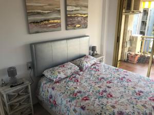 1 dormitorio con 1 cama con edredón de flores en La Moderna Apartament, en Salou