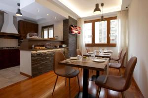 uma cozinha e sala de jantar com uma mesa de madeira e cadeiras em J24 B&B em Roma