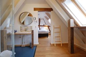 een slaapkamer op zolder met een bed en een spiegel bij 2BeSittard in Sittard