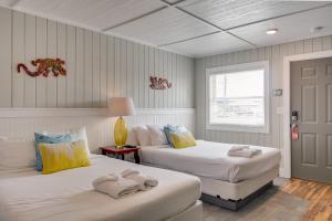 a bedroom with two beds with towels on them at See Sea Motel in Kill Devil Hills