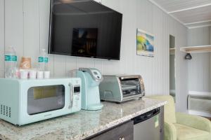 a kitchen counter with a microwave and a tv at See Sea Motel in Kill Devil Hills