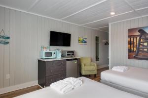 a hotel room with two beds and a tv at See Sea Motel in Kill Devil Hills