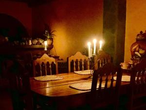 a dining room table with candles and a table with chairs at Hotel JADE in Mesa Colorada