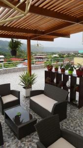 a patio with two chairs and a table and some plants at Terraza Apart Hotel in Pichanaki
