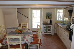 a kitchen with a table with a bowl of fruit on it at Au bon accueil in Fayence