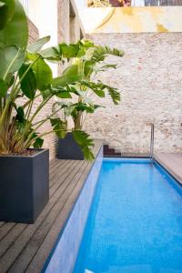 a swimming pool with plants on a wooden deck at Onix Liceo in Barcelona