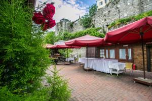 a patio with red umbrellas and tables and chairs at çarşı pansiyon in Amasra