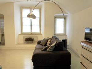 曼托瓦的住宿－Cavour 96，客厅设有一张沙发,配有两个窗户