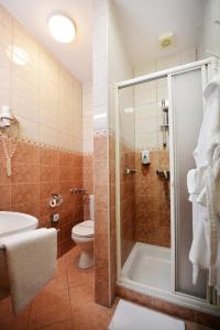 uma casa de banho com um chuveiro, um WC e um lavatório. em Panorama Hotel Noszvaj em Noszvaj