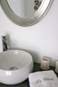 een badkamer met een witte wastafel en een spiegel bij Le Chai de Villiers in Villiers