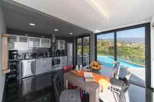 eine Küche mit Esstisch und großem Fenster in der Unterkunft Villa Clementina | Cliffs&Ocean | Heated Pool in Prazeres