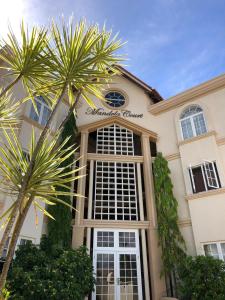 a building with a palm tree in front of it at Mandela Court Suites Grenada in Lance aux Épines