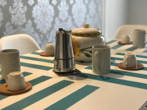 un tavolo con una tovaglia, una teiera e tazze da tè di Casa- Corso Umberto a Taranto