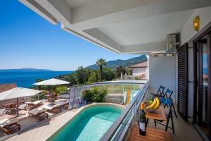 a balcony of a house with a swimming pool at Villa Roses Apartments & Wellness in Ičići