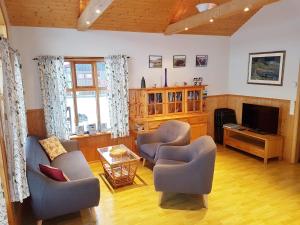 a living room with two chairs and a television at Vorsabær 2 Holiday Home in Fjall