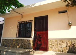 eine rote Tür an der Seite eines Hauses in der Unterkunft Casa nueva y moderna en Juchitán in Juchitán de Zaragoza