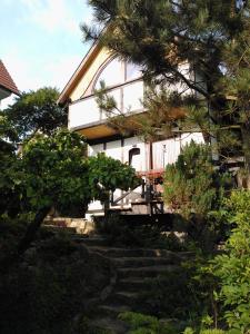 a white house with stairs in front of it at Domek na Wzgórzu in Ryn