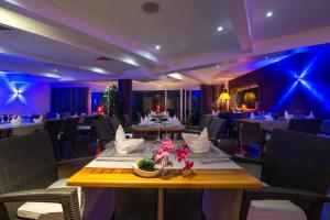 une salle à manger avec des tables et des chaises et un éclairage bleu dans l'établissement Hotel Lagon 2, à Dakar