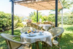 een groep tafels en stoelen onder een paraplu bij Hotel Villa delle Palme in Sapri