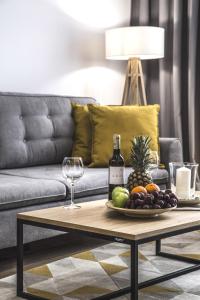 a coffee table with a plate of fruit and a bottle of wine at MyCherry - Old Town Apartment - Księcia Witolda 27 in Wrocław