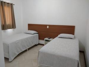 1 Schlafzimmer mit 2 Betten und einem Kopfteil aus Holz in der Unterkunft Hotel Di Fratelli in Monte Mor