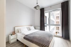 sypialnia z łóżkiem i dużym oknem w obiekcie Luksusowy apartament przy Targach w Poznaniu