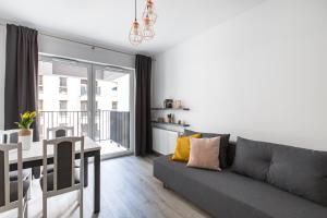 salon z szarą kanapą i stołem w obiekcie Luksusowy apartament przy Targach w Poznaniu