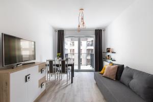 salon z kanapą i jadalnią w obiekcie Luksusowy apartament przy Targach w Poznaniu