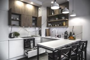 a kitchen with a white counter top and wooden cabinets at MyCherry - Old Town Apartment - Księcia Witolda 27 in Wrocław