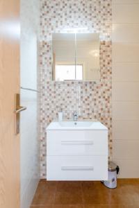a bathroom with a white sink and a mirror at Apartment Tasina in Hvar