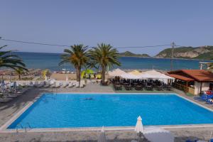 uma grande piscina com vista para o oceano em Alkyon Beach Hotel em Agios Georgios Pagon