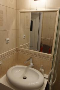 ein Badezimmer mit einem weißen Waschbecken und einem Spiegel in der Unterkunft Morski Apartament in Ustka