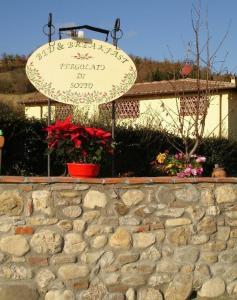 a sign on top of a stone wall at B&B Pergolato di Sotto in San Casciano in Val di Pesa