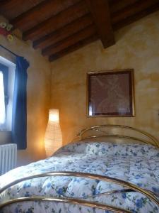 - une chambre avec un lit, une lampe et une photo dans l'établissement B&B Pergolato di Sotto, à San Casciano in Val di Pesa