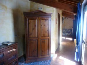 サン・カシャーノ・イン・ヴァル・ディ・ペーザにあるB&B Pergolato di Sottoの木製のキャビネットとドレッサーが備わる客室です。