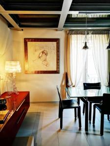 ein Esszimmer mit einem Tisch, Stühlen und einem Fenster in der Unterkunft La Boheme di Ortigia Luxury - Ortigia Holidays in Syrakus