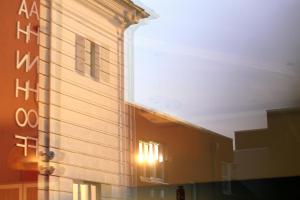 a building with the sun shining on the side of it at Hotel Alter Kreisbahnhof in Schleswig