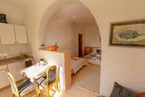 a kitchen with a table and a room with a bed at Apartmani Maja in Tučepi
